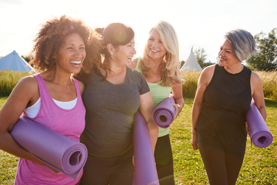 group of women outside with yoga mats