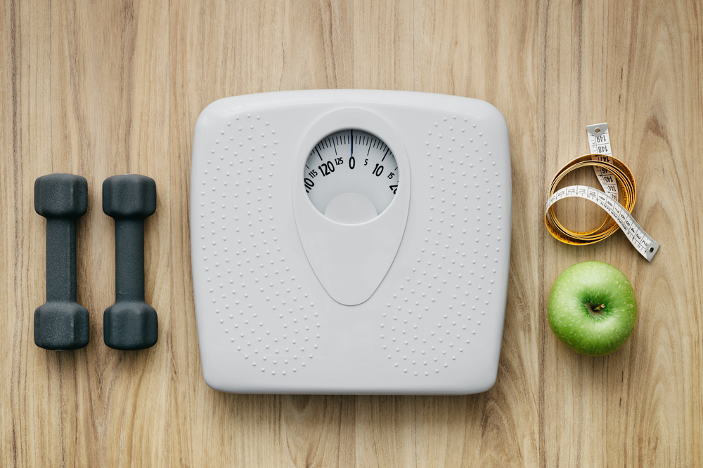 weight scale, apple, measuring tape, and dumbells